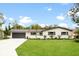 Ranch-style home with white brick exterior, gray roof, and a well-maintained lawn at 6761 15Th N Ave, St Petersburg, FL 33710