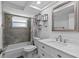 Updated bathroom with gray tile, white vanity, and bathtub at 7330 Live Oak Ln, New Port Richey, FL 34653