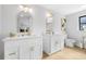 Modern bathroom with double vanity, white cabinets, and gold fixtures at 7490 Pine Valley Ln, Seminole, FL 33776