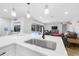 Kitchen island with sink, stainless steel faucet, and view of the living room and pool at 7490 Pine Valley Ln, Seminole, FL 33776