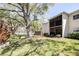 A picturesque backyard showing an apartment building with screened balcony and lush green grass at 820 Patricia Ave # 207, Dunedin, FL 34698