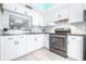 Updated kitchen featuring white cabinetry, modern appliances, and decorative backsplash, perfect for culinary enthusiasts at 820 Patricia Ave # 207, Dunedin, FL 34698