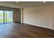 Spacious living room with hardwood floors and sliding glass doors to the backyard at 10725 Tippecanoe Pl, Parrish, FL 34219