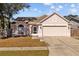 One-story house with pink stucco exterior, two-car garage, and fenced yard at 1202 Sawdust Ct, Valrico, FL 33596