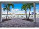 Framed waterfront view from a covered outdoor patio with tropical landscaping at 143 94Th Ave # 2, Treasure Island, FL 33706