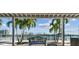 Inviting waterfront view showcasing a bench and lush palm trees, framed by a covered outdoor area at 143 94Th Ave # 2, Treasure Island, FL 33706