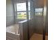 Elegant bathroom featuring a soaking tub, glass-enclosed shower, and neutral tile work at 16025 7Th E Ave, Bradenton, FL 34212