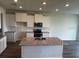 Modern kitchen featuring white cabinets, granite countertops, stainless steel appliances, and a central island at 16025 7Th E Ave, Bradenton, FL 34212