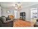 Bright living room featuring hardwood floors, comfy sofas, and a large TV at 2609 Meadowbrook Dr, Palm Harbor, FL 34684