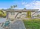 Backyard patio with yellow door and small sitting area at 35 Juniper Way, Clearwater Beach, FL 33767
