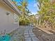Landscaped backyard with patio, table, and tropical foliage at 35 Juniper Way, Clearwater Beach, FL 33767