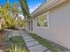 Side view of the house with stone path and tropical plants at 35 Juniper Way, Clearwater Beach, FL 33767