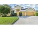 Beautiful yellow house with a two-car garage and well-manicured lawn at 4039 Eagles Nest Dr, Valrico, FL 33596