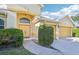 House exterior featuring a yellow front door and two-car garage at 4039 Eagles Nest Dr, Valrico, FL 33596