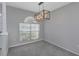 Dining area with grey walls and carpet flooring, featuring a modern chandelier at 4953 Edgewater Ln, Oldsmar, FL 34677