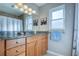 Bathroom with granite countertop, wood cabinets, and shower with curtain at 8408 Monarch Cir, Seminole, FL 33772