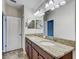 Bathroom featuring double vanity with granite countertops and large mirrors at 15403 Fire Rock Pl, Ruskin, FL 33573