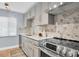Modern kitchen with stainless steel appliances, custom grey cabinets, and a unique marble backsplash at 2060 Marilyn St # 241, Clearwater, FL 33765