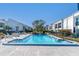 Community pool surrounded by white buildings and black fencing on a sunny day at 2060 Marilyn St # 241, Clearwater, FL 33765