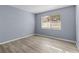 Bright bedroom with wood-look floors and a window with blinds at 3034 Eastland Blvd # D108, Clearwater, FL 33761