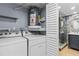 Laundry room with washer, dryer, water heater, and bathroom access at 3034 Eastland Blvd # D108, Clearwater, FL 33761