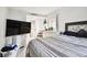 Bedroom with a large TV, dresser, and striped comforter at 36750 Us Highway 19 N # 01104, Palm Harbor, FL 34684