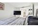 Spacious bedroom with a large TV, dresser, and striped comforter at 36750 Us Highway 19 N # 01104, Palm Harbor, FL 34684