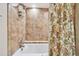 Tiled shower with built-in bench and patterned shower curtain at 36750 Us Highway 19 N # 09122, Palm Harbor, FL 34684