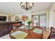 Dining area with round table and chandelier, overlooking the living room at 36750 Us Highway 19 N # 09122, Palm Harbor, FL 34684