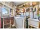 Bright laundry room with washer, dryer, and storage shelves at 5312 Mary St, Zephyrhills, FL 33542