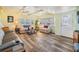 Spacious living room with gray reclining sofa and wood-look floors at 5312 Mary St, Zephyrhills, FL 33542