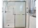 Updated shower with a sliding glass door and grab bars at 5312 Mary St, Zephyrhills, FL 33542