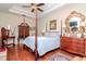 Main bedroom with hardwood floors, a post bed, and ample storage at 5314 Golden Isles Dr, Apollo Beach, FL 33572