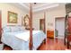 Main bedroom with hardwood floors, a post bed, and ensuite bathroom at 5314 Golden Isles Dr, Apollo Beach, FL 33572