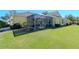 Charming yellow house with a screened patio and well-manicured lawn at 5314 Golden Isles Dr, Apollo Beach, FL 33572