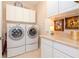 Bright laundry room with washer, dryer, and ample cabinetry at 5314 Golden Isles Dr, Apollo Beach, FL 33572