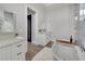Bright bathroom featuring a modern tub, double vanity with white cabinets, and a stylish shower with glass door at 5713 Tybee Island Dr, Apollo Beach, FL 33572