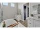 Bright bathroom featuring a modern tub, double vanity with white cabinets, and a stylish shower with glass door at 5713 Tybee Island Dr, Apollo Beach, FL 33572