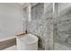 Elegant bathroom featuring a standalone tub, a decorative geometric tile accent wall, and a walk-in shower at 5713 Tybee Island Dr, Apollo Beach, FL 33572