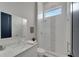 Well-lit bathroom features a modern vanity, white tiled shower with glass door, and a geometric tile accent at 5713 Tybee Island Dr, Apollo Beach, FL 33572