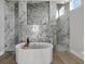 Luxurious bathroom featuring a standalone tub, dual walk-in showers and a decorative geometric tile accent wall at 5713 Tybee Island Dr, Apollo Beach, FL 33572