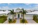 Stunning elevated view of a modern two-story home with a metal roof, lush landscaping, and a two-car garage at 5713 Tybee Island Dr, Apollo Beach, FL 33572