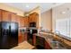 Modern kitchen with wood cabinets, granite counters and black appliances at 8455 Shallow Creek Ct, New Port Richey, FL 34653