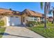 Front view of a tan, two-unit building with a white garage door at 1006 Cara Dr # 1006, Largo, FL 33771