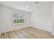 Bright, empty bedroom features hardwood floors, a window with blinds, and white walls at 10524 Hidden Banks Gln, Parrish, FL 34219