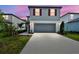 Home with a two-car garage, concrete driveway, and red shutters under a twilight sky at 10524 Hidden Banks Gln, Parrish, FL 34219