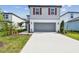 Charming two-story home with gray exterior, red shutters, a concrete driveway and attached two-car garage at 10524 Hidden Banks Gln, Parrish, FL 34219