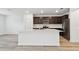 Modern kitchen featuring stainless steel appliances, dark wood cabinetry, an island and light countertops at 10524 Hidden Banks Gln, Parrish, FL 34219