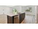 Kitchen island with stainless steel dishwasher, light countertops and dark cabinetry in a light-filled room at 10524 Hidden Banks Gln, Parrish, FL 34219
