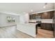 Kitchen featuring stainless appliances, dark cabinets and light countertops open to a bright living space at 10524 Hidden Banks Gln, Parrish, FL 34219